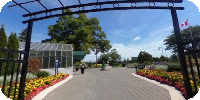 View of Chinguacousy Park Greenhouse with the waving Canadian flag.